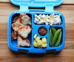 a blue lunch box filled with food on top of a wooden table