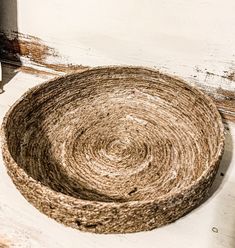 a basket made out of jute sitting on the floor in front of a door