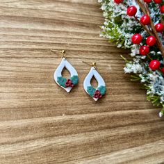 two pairs of earrings sitting on top of a wooden table