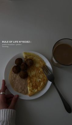 a person holding a fork over a plate with food on it and a cup of coffee