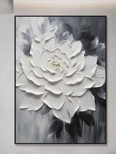 a large white flower on a black and white background in a living room with grey walls