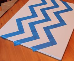 a blue and white zigzag painted on top of a wooden floor with tape