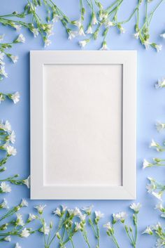 an empty white frame surrounded by flowers on a blue background