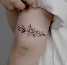 a woman's arm with a flower tattoo on the left side of her arm