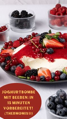 a cake covered in berries and cream sitting on top of a table