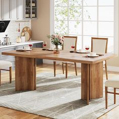 a dining room table and chairs in front of a window