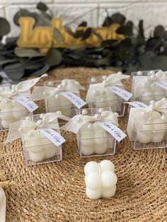 small white candles are sitting on a wicker table with tags attached to them that read, i do not know what they are