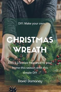 a woman is decorating a christmas wreath with pine cones and berries on the table