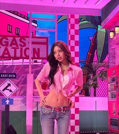 a woman standing in front of a pink and white wall with neon signs on it