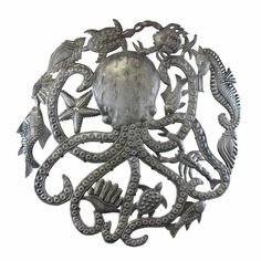 an octopus brooch with sea creatures on it's back and sides, in silver