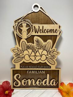 a wooden sign that says, welcome to the family with flowers in front of it