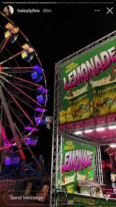 an amusement park at night with ferris wheel and lemonade advertisement