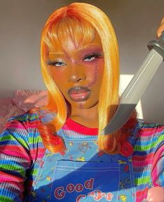 a woman with yellow hair and makeup holding a knife