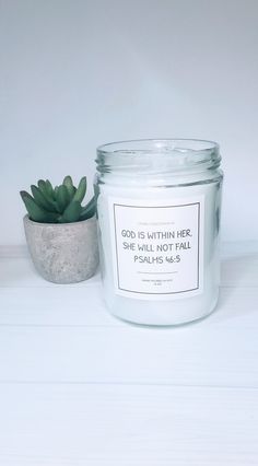 a white candle sitting next to a potted plant