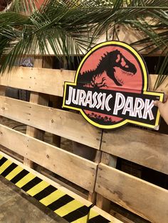 there is a sign that says jurasic park on the side of a fence