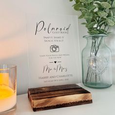 a wooden sign sitting on top of a table next to a candle