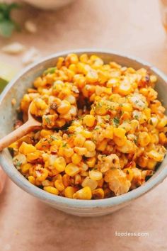 a bowl filled with corn on top of a table