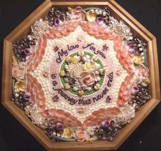 a close up of a clock with flowers and words on the front cover in wood