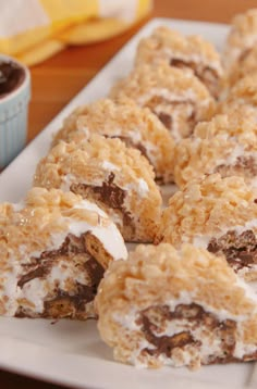 several desserts are arranged on a white plate