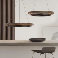 the modern lighting fixture is suspended over the countertop in this room with two chairs and a table