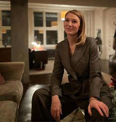 a woman sitting on top of a couch in a living room