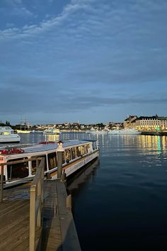 two boats are docked on the water at night