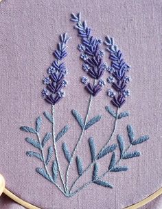 a close up of a embroidery on a piece of cloth with flowers in the middle