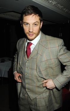 a man in a suit and tie posing for the camera