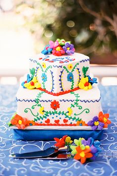 a three tiered cake sitting on top of a table next to a knife and fork