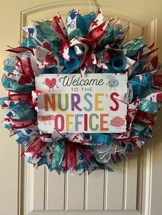 a welcome to the nurse's office wreath is hanging on a door with red, white and blue ribbons