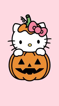 hello kitty sitting on top of a pumpkin