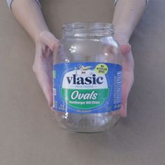 a person holding a glass jar filled with water