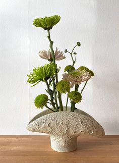 a vase with flowers in it sitting on a table