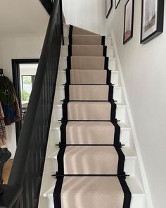 a staircase with carpeted steps and pictures on the wall