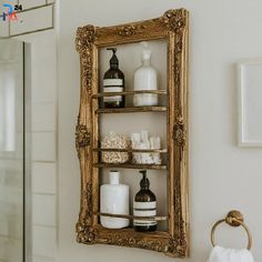 a gold framed shelf with soap, lotion and other bathroom items on it next to a shower