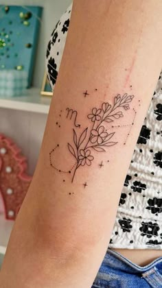 a woman's arm with a tattoo on it that has flowers in the middle