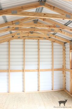 the inside of a building that is being built with wood and white paint on the walls