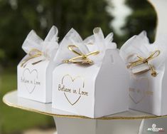 three white boxes with gold hearts on them