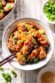 two bowls filled with chicken and vegetables next to chopsticks