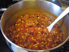 a pot full of chili and corn on the stove