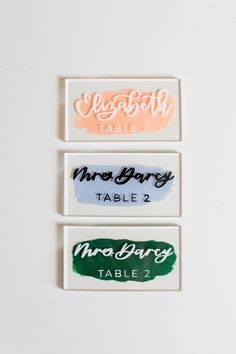 three different type of name tags on a white surface, each with the same color and font