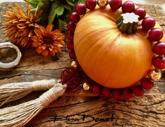 a close up of a pumpkin on a table with flowers and other items around it