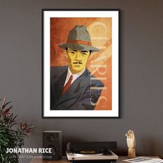 a framed portrait of a man in a suit and hat on a wall above a desk