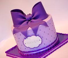 a purple and white cake with a big bow on top