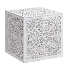 a decorative white box with an intricate design on the front and sides, sitting on a white surface