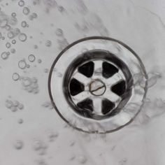 the water is running down the drain in the sink, and it looks like bubbles