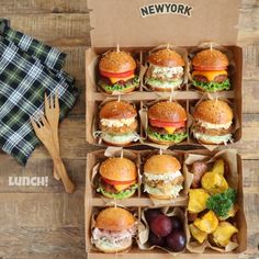 a box filled with lots of different types of sandwiches on top of a wooden table