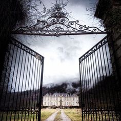 an open gate leading to a large house