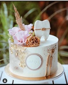 a white cake decorated with flowers and toothbrushes