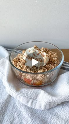 a glass bowl filled with cereal and marshmallows on top of a white towel